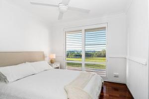 a white bedroom with a bed and a large window at The Bower - Byron Hinterland in Teven +18 photos