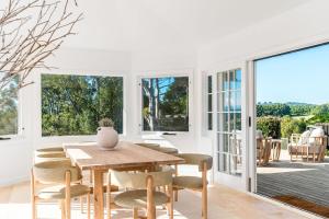 a dining room with a wooden table and chairs at The Bower - Byron Hinterland in Teven