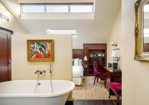 a bathroom with a bath tub and a bedroom at The Vagabond Club, a Tribute Portfolio Hotel Singapore in Singapore +73 photos