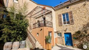 a brick building with a balcony and a blue door at Villa Modéliacus in Meuilley
