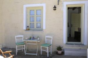 a table and chairs sitting outside of a house at Oak Farm Guest House Junior in Andros