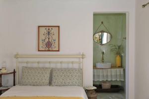a bedroom with a bed with a mirror and a mirror at Oak Farm Guest House Junior in Andros