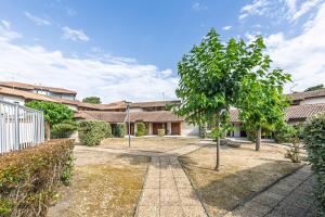 a courtyard with a tree and a building at Villa Lolo, Piscine et Terrasse in Moliets-et-Maa