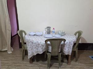 a table with a white table cloth and chairs at Anigo 3bhk, Itanagar in Itānagar