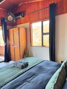 a bedroom with a large bed with a window at Matilo Cabins - Cactus Deck with Hot-tub and Fireplace in Calitzdorp