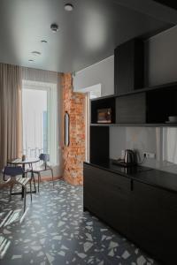 a kitchen with black cabinets and a table with chairs at Resume apartments in Kaunas