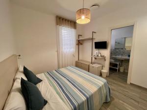 a bedroom with a bed and a desk and a television at Dimora del Corso - Rooms in Mattinata
