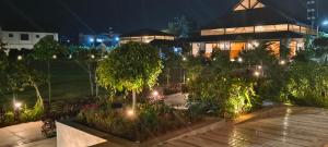 a garden at night with lights in front of a building at Tridalam Resort in Bangalore