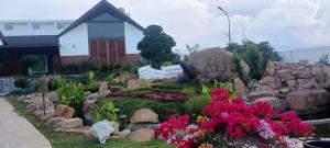 a garden with flowers and rocks in front of a building at Tridalam Resort in Bangalore