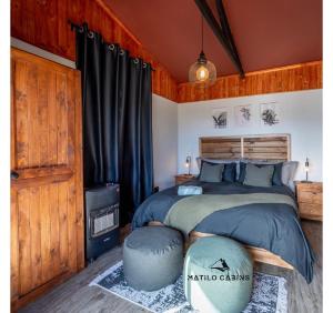 a bedroom with a large bed with aokedokedokedokedoked at Matilo Cabins - Cactus Deck with Hot-tub and Fireplace in Calitzdorp