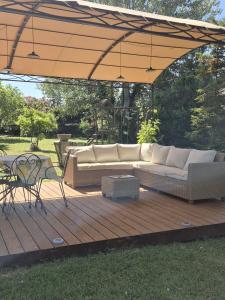 a patio with a couch and a table on a deck at La Maison Verte in Tulette