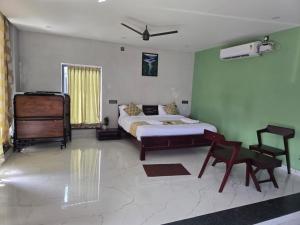 a bedroom with a bed and a chair and a desk at Silver Valley Villas in Yercaud