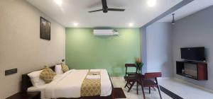 a bedroom with a bed and a couch and a tv at Silver Valley Villas in Yercaud