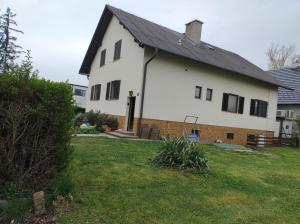 a white house with a black roof and a yard at Ferienhaus mit Garten in Traiskirchen