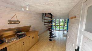 a kitchen with a spiral staircase in a room at Nowa Siesta Camp Łeba in Nowęcin