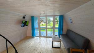 a living room with a couch and a large window at Nowa Siesta Camp Łeba in Nowęcin