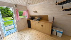 a small kitchen in a tiny house with a window at Nowa Siesta Camp Łeba in Nowęcin +23 photos