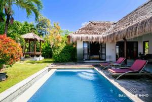 a villa with a swimming pool in front of a house at villa TOYA NING in Ungasan