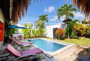 a swimming pool with lounge chairs and an umbrella at villa TOYA NING in Ungasan