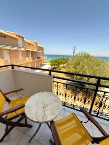 a balcony with a table and chairs and the ocean at Vaso Alykanas Studios in Alikanas