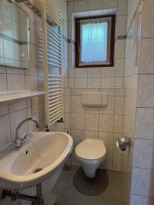 a white bathroom with a sink and a toilet at Appartementhaus Grocke in Wagrain +35 photos
