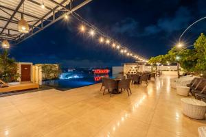 a rooftop patio with chairs and lights at night at Atanaya Kuta Bali in Kuta