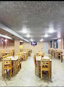 a dining room with wooden tables and wooden chairs at Relax inn in Kobuleti