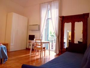 ein Wohnzimmer mit einem Tisch, einem Tisch und einem Fenster in der Unterkunft B&B Amedeo in Neapel