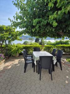 a table and chairs on a patio under a tree at Apartmani Mira in Rab