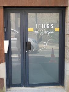 a door to a store with a sign on it at Le Logis du Donjon 2 in Les Herbiers