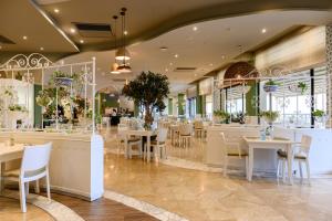 a restaurant with tables and chairs in a room at Verdi St George's Bay Marina in St. Julianʼs