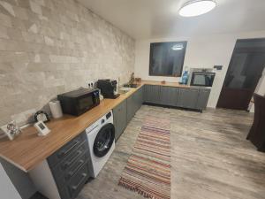 a kitchen with a washing machine and a microwave at Casa Alina in Nehoiu +19 photos