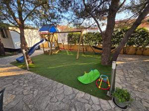 a playground with a slide and a swing set at Mobile homes Bonaca in Srima