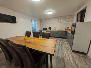 a dining room with a wooden table and chairs at Casa Alina in Nehoiu