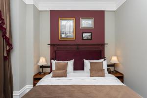 a bedroom with a large bed with a red wall at Hayasa Hotel Old Yerevan in Yerevan