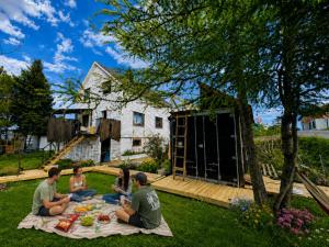 a group of people sitting around a picnic blanket at Alfa Room - The LOWFO House Lofoten in Moskenes