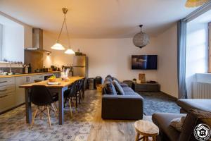 a kitchen and living room with a table and a couch at La Maison d'Aure in Arreau +15 photos
