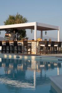 a group of chairs and a table next to a swimming pool at Lagos Mare Hotel in Agios Prokopios