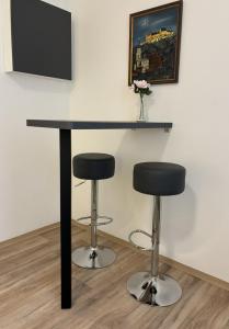 a black table and two stools in a room at Apartment am Bahnhof mit Self-Check-in in Coburg