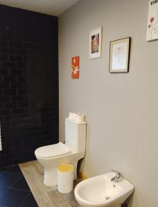 a bathroom with a white toilet and a sink at Telhadosolitario in São Pedro da Cova +12 photos