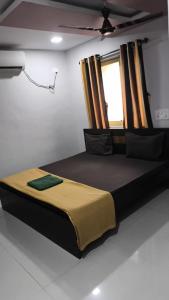 a large bed in a room with a window at Hotel Radha krishna in Neral