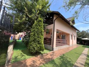 a house with a green yard in front of it at Casa Naomi in Eforie Nord