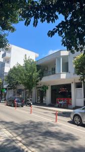 a building with cars parked in front of a street at Laska's Rooms Sarandë in Sarandë