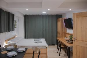 a living room with a bed and a table and a desk at Nad vasjo in Železniki