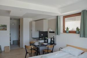 a room with a bed and a kitchen with a table at Nad vasjo in Železniki