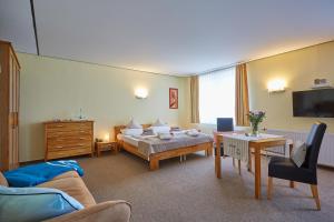 a hotel room with a bed and a couch at Strandwetter Dünenhotel in Borkum