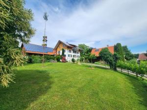 a large yard with a house and a windmill at Öko Wohnung Garten und Pool in Lindau-Bodolz