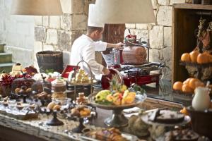 ein Koch, der Essen hinter einer Theke in einer Küche zubereitet in der Unterkunft Torre Del Parco in Lecce