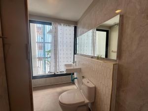 a bathroom with a toilet and a sink and a window at The Elegant Bangna Suvarnabhumi in Ban Map Prasoe +29 photos