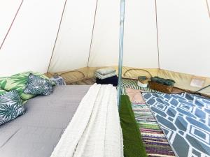 a bed in a tent with pillows on it at Lahemaa Nature Glamping - Koit in Vihasoo +16 photos